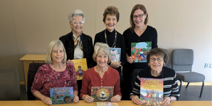 St. Cloud Reading Room Society members holding books added to the library collection