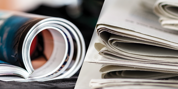 magazines in a roll and a stack of newspapers
