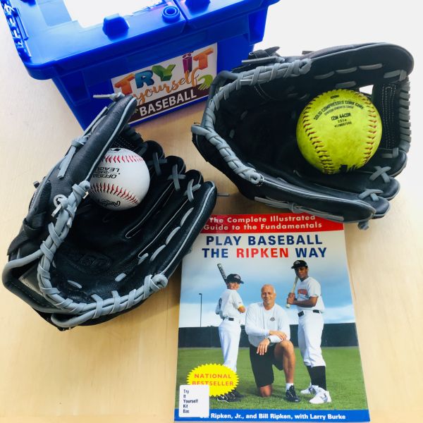 Baseball Kit with two baseballs and gloves and a book about baseball