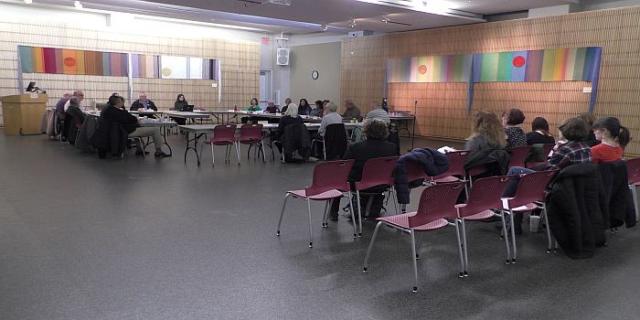 Board room with several people seated.