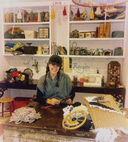 Jen Anfinson pictured in her studio, with art supplies all around.