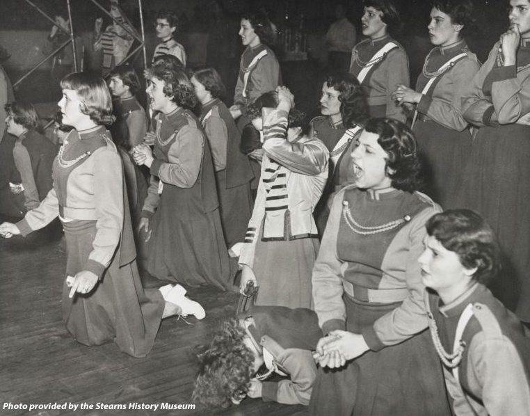 Cheer squad from the 1950s yelling during a basketball game