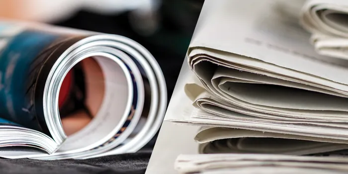 magazines in a roll and a stack of newspapers