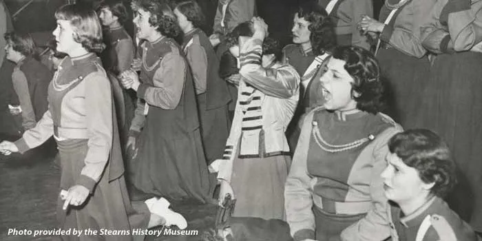 ladies in uniforms on their knees, appearing to be shouting and anxious